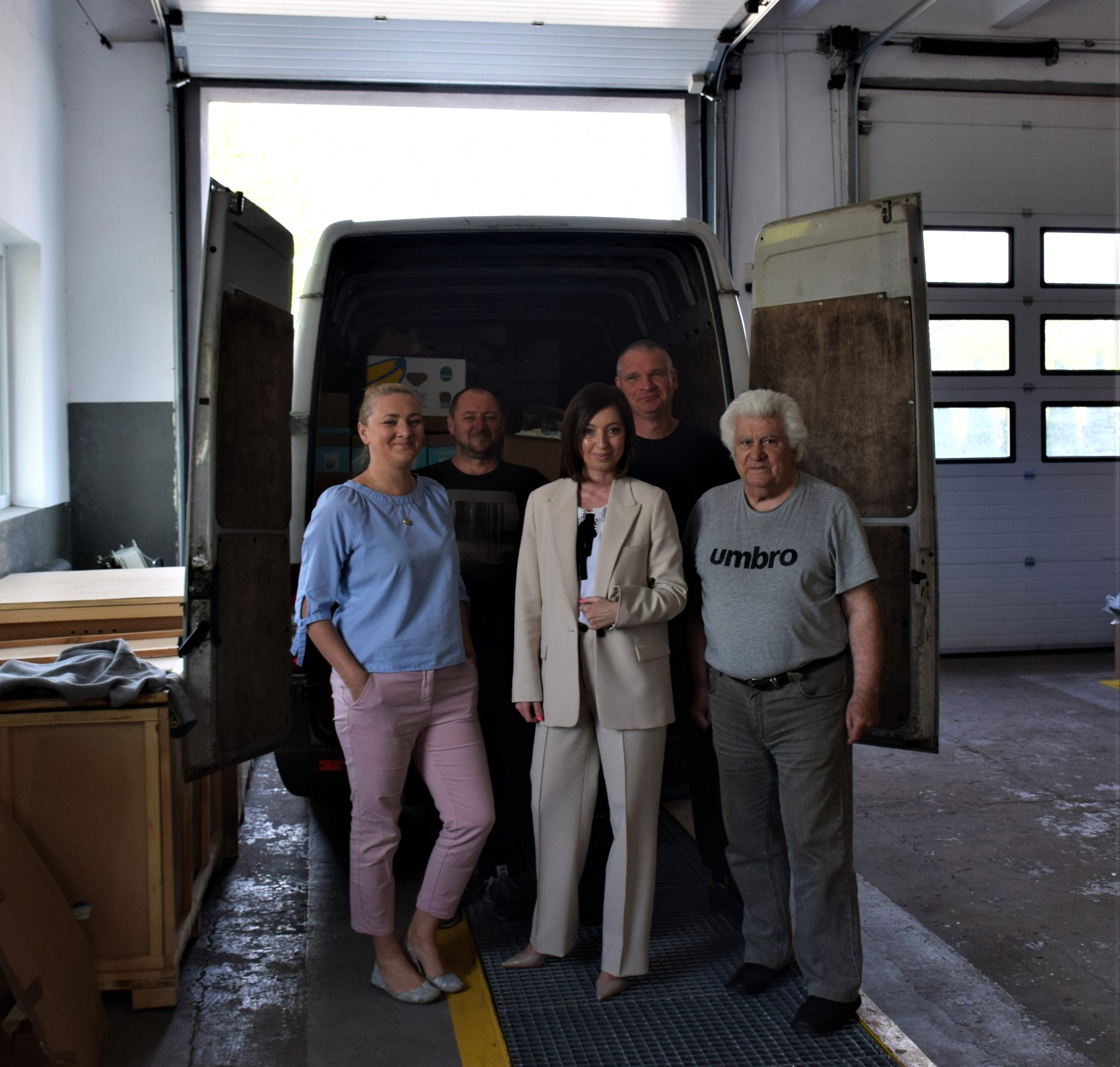 Na zdjęciu 5 osób - pracownicy Starostwa oraz kierowca, który transportuje dary na Ukrainę na tle samochodu zapakowanego darami